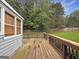 View of the wooden deck with railing overlooking the backyard at 401 Grove Pointe Ct, Locust Grove, GA 30248