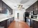 Modern kitchen features dark cabinets, hardwood floors, and stainless steel appliances at 401 Grove Pointe Ct, Locust Grove, GA 30248