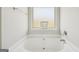 Bathroom showcasing a soaking tub with a frosted window at 5237 Halcyon Ct, Morrow, GA 30260