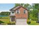 Two-story brick home with attached garage and well-maintained landscaping near lake at 5237 Halcyon Ct, Morrow, GA 30260