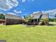 Spacious backyard featuring a deck, lush greenery, and a detached garage, perfect for outdoor enjoyment at 382 Knox Chapel Rd, Social Circle, GA 30025