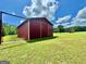 Large metal red barn with sliding doors, on a green grassy field with trees in the background at 382 Knox Chapel Rd, Social Circle, GA 30025