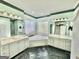 Bright bathroom features dual vanities, a soaking tub with privacy glass block window, and black tile floors at 382 Knox Chapel Rd, Social Circle, GA 30025