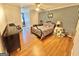 Bedroom features wood floors, a ceiling fan, striped wallpaper, and comfortable bed with Americana themed decor at 382 Knox Chapel Rd, Social Circle, GA 30025