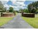 Long paved driveway leading to a beautiful home, flanked by brick columns and white fencing at 382 Knox Chapel Rd, Social Circle, GA 30025