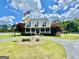 Beautiful home with a circular driveway, mature trees, a flagpole, and a covered front porch at 382 Knox Chapel Rd, Social Circle, GA 30025