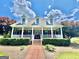 Charming brick home with a large covered front porch, dormer windows, and manicured landscaping at 382 Knox Chapel Rd, Social Circle, GA 30025
