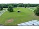 Aerial view of the expansive green property featuring a horse shelter and white fencing at 382 Knox Chapel Rd, Social Circle, GA 30025