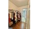Walk-in closet with mirror showcasing clothing, wood floors, and access to an additional closet at 382 Knox Chapel Rd, Social Circle, GA 30025