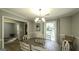 Dining area features a wooden table, chandelier, and large window with natural light at 3180 Sweetbriar Dr, Villa Rica, GA 30180
