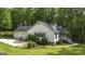 House with a two-car garage, manicured lawn, and stone-lined garden beds at 3180 Sweetbriar Dr, Villa Rica, GA 30180
