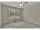 This bedroom features neutral paint, a ceiling fan, and a window at 1341 Huey Rd, Douglasville, GA 30134