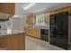 Well-lit kitchen with wooden cabinets, laminate countertops, and black appliances at 1341 Huey Rd, Douglasville, GA 30134