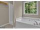 Main bathroom with a tub and shower providing natural light with a large window at 1341 Huey Rd, Douglasville, GA 30134