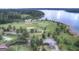 Panoramic aerial view showcasing a golf course and a vast, serene lake at 1141 Pebble Creek Ln, Locust Grove, GA 30248
