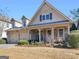 Charming two-story home with a stone facade, covered porch, and well-maintained landscaping at 1141 Pebble Creek Ln, Locust Grove, GA 30248