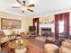 Inviting living room featuring a fireplace, ceiling fan, and stylish decor at 1141 Pebble Creek Ln, Locust Grove, GA 30248