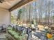 Covered patio with comfortable seating and a serene view of the wooded backyard at 1141 Pebble Creek Ln, Locust Grove, GA 30248