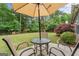 Inviting backyard patio setup with umbrella-covered table and chairs, perfect for outdoor relaxation at 243 Kensington Trce, Stockbridge, GA 30281