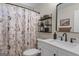 Bathroom with framed mirror, open shelves, and a neutral shower curtain at 243 Kensington Trce, Stockbridge, GA 30281
