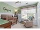 A bedroom featuring wood accents and a gray rocking chair by a sunlit window at 243 Kensington Trce, Stockbridge, GA 30281