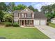 Charming two-story home featuring a landscaped front yard, red shutters, and a two-car garage at 243 Kensington Trce, Stockbridge, GA 30281