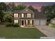 Charming two-story home featuring a landscaped front yard, red shutters, and a two-car garage at 243 Kensington Trce, Stockbridge, GA 30281