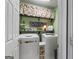 A green laundry room with stacked washer and dryer and built in storage shelves at 243 Kensington Trce, Stockbridge, GA 30281
