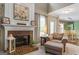 Cozy living room with fireplace, chair with ottoman, and view into the dining area at 243 Kensington Trce, Stockbridge, GA 30281