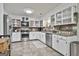 Well-lit kitchen featuring stainless appliances, stone counters, and ample white cabinet space at 1234 Coweta Heard Rd, Hogansville, GA 30230