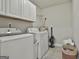 Well-lit laundry room with modern appliances, white cabinets, and tiled floors at 1234 Coweta Heard Rd, Hogansville, GA 30230