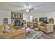 Comfortable living area showcasing a rustic stone fireplace and hardwood floors with ceiling fan at 1234 Coweta Heard Rd, Hogansville, GA 30230