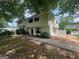 Two-story townhome with light siding and a walkway leading to the front door and driveway, surrounded by mature trees at 1466 Pine Log Ne Rd # A, Conyers, GA 30012