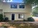 Close-up of the townhome's front entrance with a black door, siding, and a small garden area at 1466 Pine Log Ne Rd # A, Conyers, GA 30012