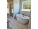Bright bathroom with a soaking tub beneath a window, a glass enclosed shower, and tile flooring at 1715 Crumbley Rd # 2, Mcdonough, GA 30252