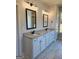 Bathroom with double vanity, granite countertops, white cabinets, and framed mirrors with modern light fixtures at 1715 Crumbley Rd # 2, Mcdonough, GA 30252