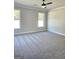 Bright bedroom with plush grey carpet, neutral walls, and large windows overlooking the outdoors at 1715 Crumbley Rd # 2, Mcdonough, GA 30252