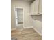 Laundry room with white cabinets, wood-look flooring, and access to a closet area at 1715 Crumbley Rd # 2, Mcdonough, GA 30252
