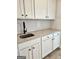 Laundry room features white cabinets with a granite countertop and backsplash at 1715 Crumbley Rd # 2, Mcdonough, GA 30252