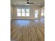 Open living room with large windows and a glass door, featuring hardwood floors and a ceiling fan at 1715 Crumbley Rd # 2, Mcdonough, GA 30252