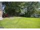 The backyard features mature shade trees and a grassy lawn at 6369 Havenridge Dr, Riverdale, GA 30274