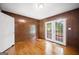 Bedroom featuring wood paneling, wood floors, and glass doors that lead to an outdoor space at 6369 Havenridge Dr, Riverdale, GA 30274