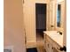Bathroom sink and vanity with floral shower curtain and tile flooring at 8039 Woods Ln, Jonesboro, GA 30236