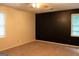 Bedroom featuring cozy carpet, two windows, and a dark accent wall at 8039 Woods Ln, Jonesboro, GA 30236