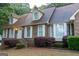 Inviting brick home with dormer windows and a beautifully landscaped front entrance at 8039 Woods Ln, Jonesboro, GA 30236