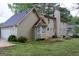 Two-story home with a bay window and chimney, nestled in a yard, with a detached two-car garage at 8039 Woods Ln, Jonesboro, GA 30236