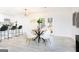 Open-concept dining area with stylish round table, modern chairs, and views of the updated kitchen at 8479 Alden Dr, Riverdale, GA 30274