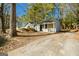 Well-kept single-story home with a covered porch and a concrete driveway surrounded by mature trees at 8479 Alden Dr, Riverdale, GA 30274