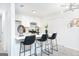 Renovated kitchen showcasing white cabinets, stainless steel appliances, island with barstools, and modern lighting at 8479 Alden Dr, Riverdale, GA 30274