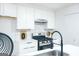 Modern kitchen featuring white cabinetry, stainless steel appliances, and marble tile backsplash at 8479 Alden Dr, Riverdale, GA 30274